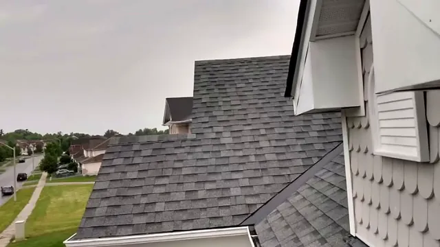Grey shingle roof meeting white siding on a two-storey home